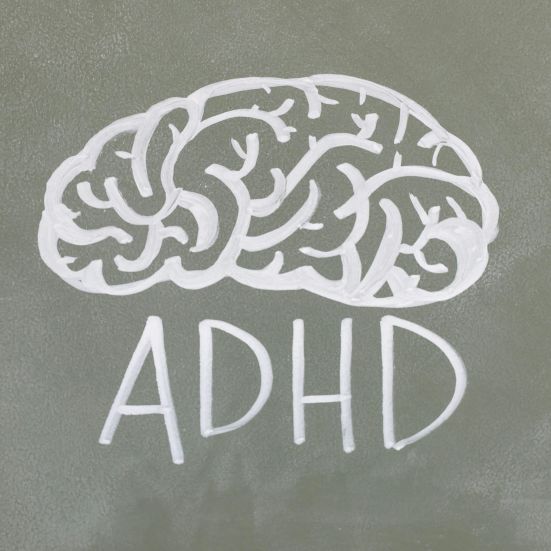 En tegning af en hjerne med hvid tusch med skriften ADHD nedenunder 