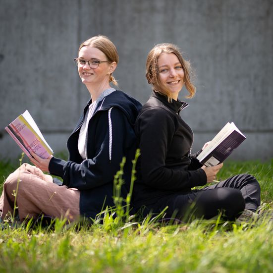 Yogainstruktør Helene Tost og litteraturformidler Mette Bjellsäter siddende ryg mod ryg